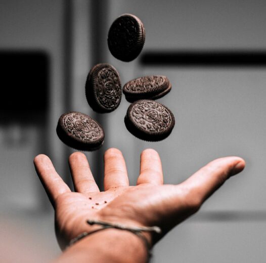 Photo of hand tossing up chocolate cookies